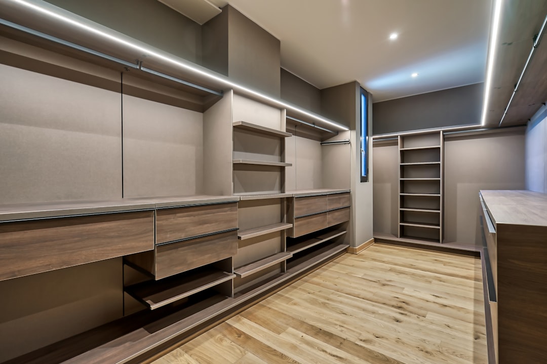 a-large-walk-in-closet-with-a-wooden-floor-22behqa7smo